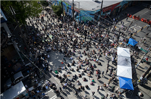 A birds eye view of a large crowd of people sitting in the middle of an intersection