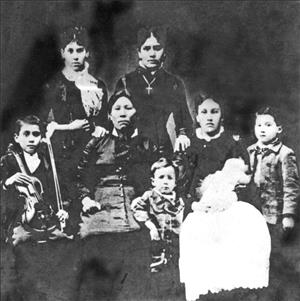 A portrait of a Native American woman in a dress with seven children of different ages positioned around her, one of them holding a violin