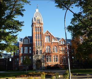 Red brick, Richardsonian Romanesque building with a five story tower at the entrance