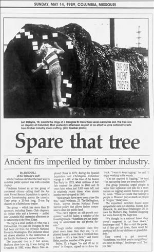 A newspaper headline shows a child looking closely at the cut end of a large log above the words Spare That Tree