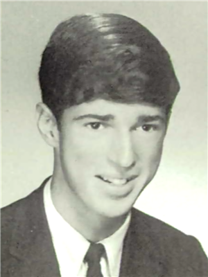 A head and shoulders portrait of a young white man in a tie and jacket. 