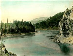 A wide river winds through a forested canyon. 