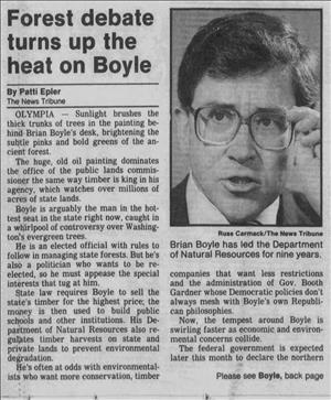 A newspaper clipping shows a man talking and reaching for his eyeglasses next to a headlines that says Forest Debate Turns Up The Heat On Boyle. 