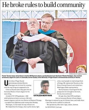 An elderly man in a black robe holds a paper between his hands while another man wraps a large ribbon around his neck. Above are the words he broke rules to build community. 