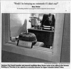 Newspaper article shows a woman sitting at her desk behind an office window. The headline reads would I be betraying my community if I didn't run?