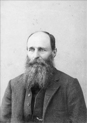 Borst sitting in a long beard and heavy suit