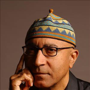 Gayton posing in glasses and multicolor woven hat