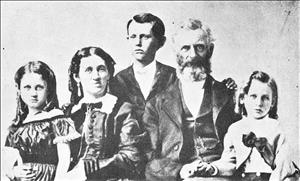 A family of five pose seated
