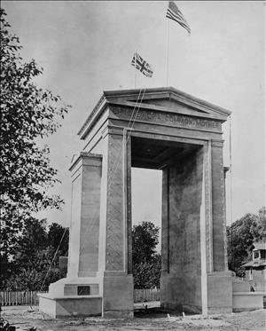 A rectangular stone archway with a British and American Flag which reads "Children of a Common Mother"