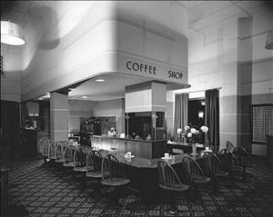 Coffee shop interior with rounded art deco design and a bar with seating in a U formation