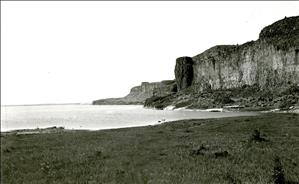 Black and white image of cliffs above a lake and lakeshore