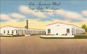 Color postcard of two white, one story hotel buildings